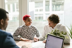 woman smiling while man signs paper