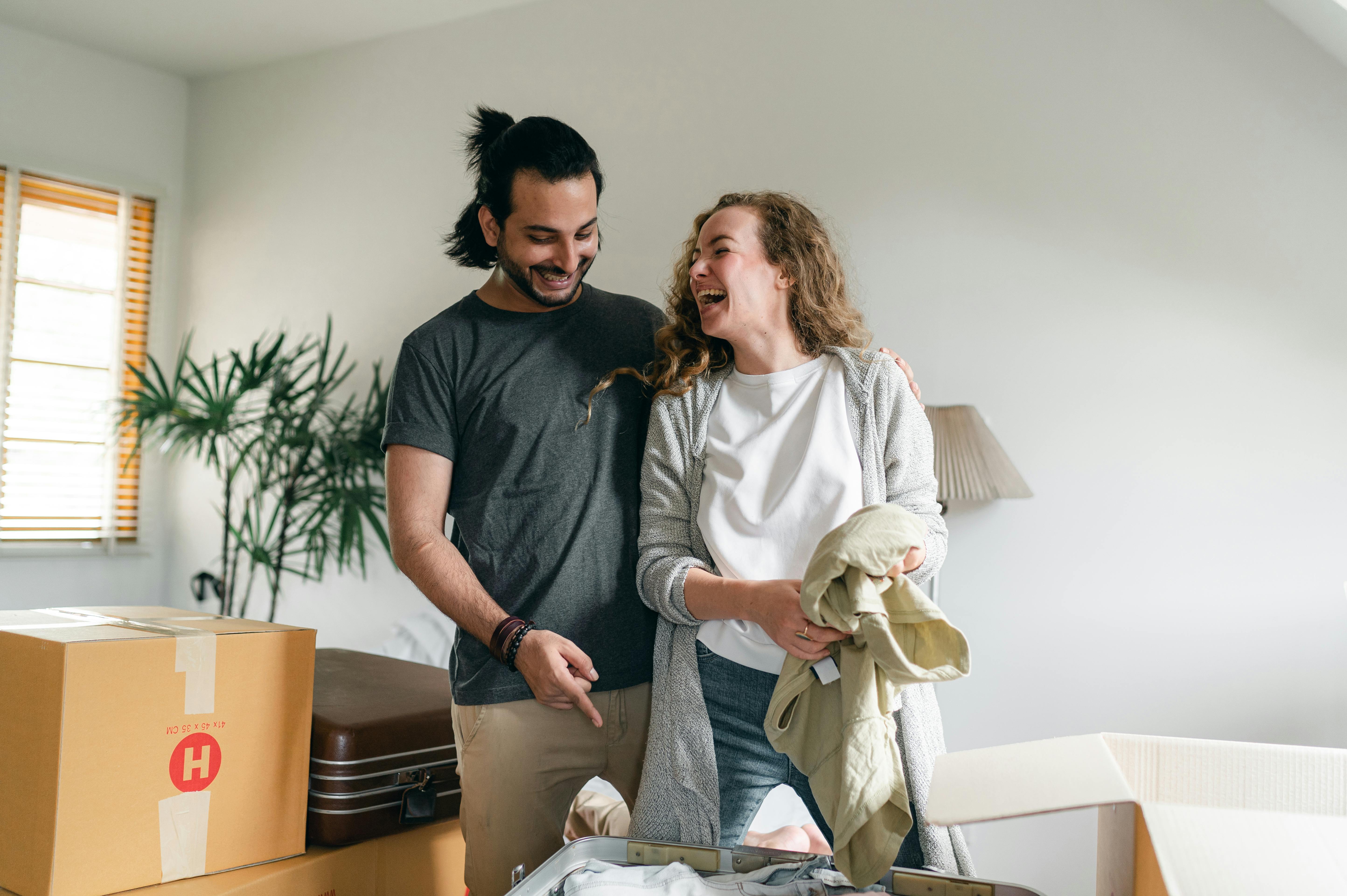man and woman moving into new house laughing